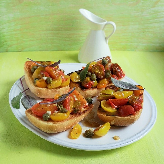 Platter_of_4_bruschetta_topped_with_tomatoes_sage_and_capers
