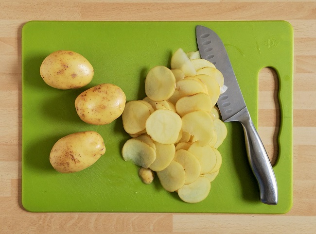 Thinly_slicing_Charlotte_potatoes_for_pilau_cake