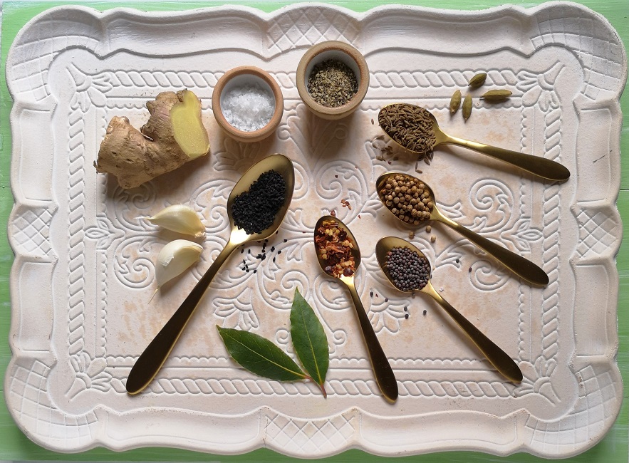 An_array_of_whole_spices_and_seasonings_on_a_wooden_tra_ready_to_flavour_mango_chutney