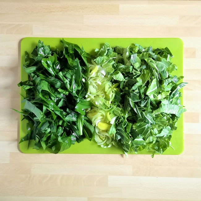 Green_chopping_board_with_chopped_wild_garlic_leaves_shredded_leek_and_shredded_spring_greens