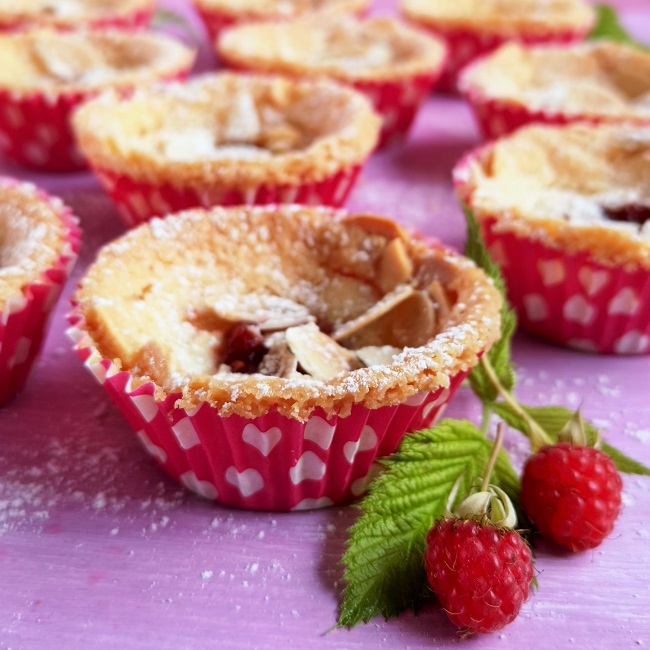 Close-up_on_raspberry_and_almond_shorties_with_fresh_raspberries_and_leaves