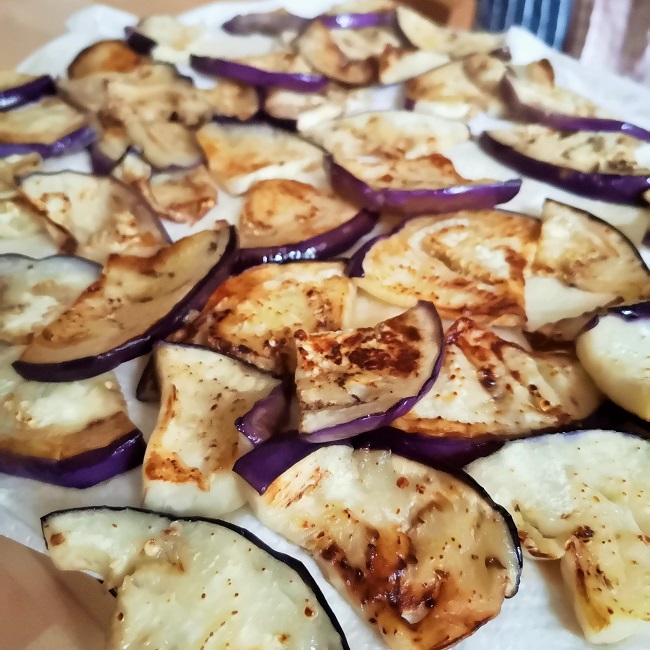 Aubergine_(eggplant)_slices_salted_and_fried_draining_on_kitchen_paper