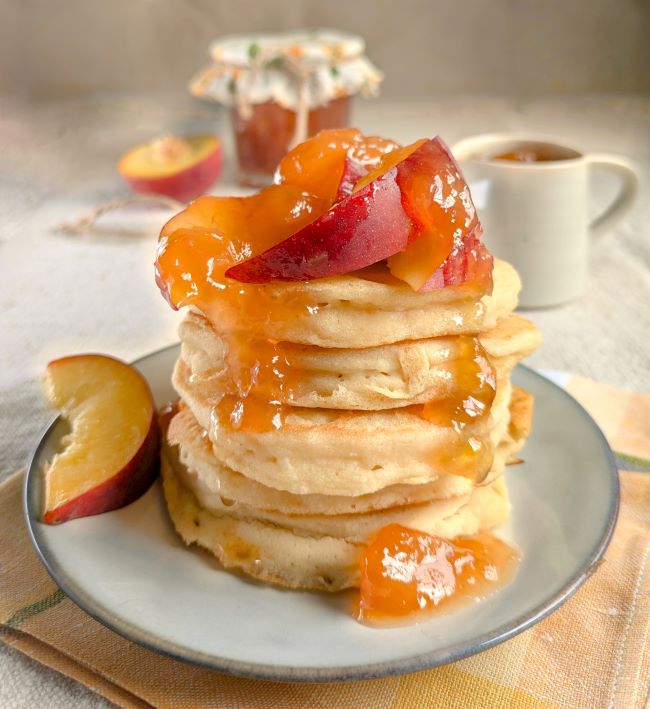 A_stack_of_gluten-free_dairy-free_vegan_pancakes_with_peaches